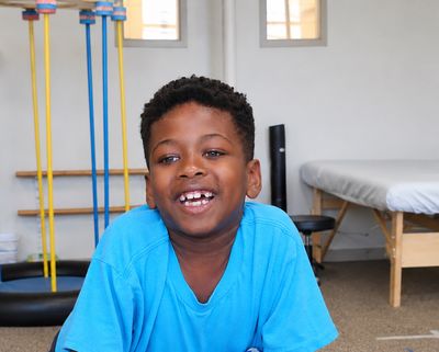 A smiling boy in the therapy gym