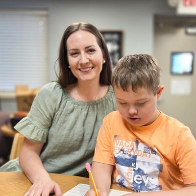 A speech therapist and a young boy playing together at a table
